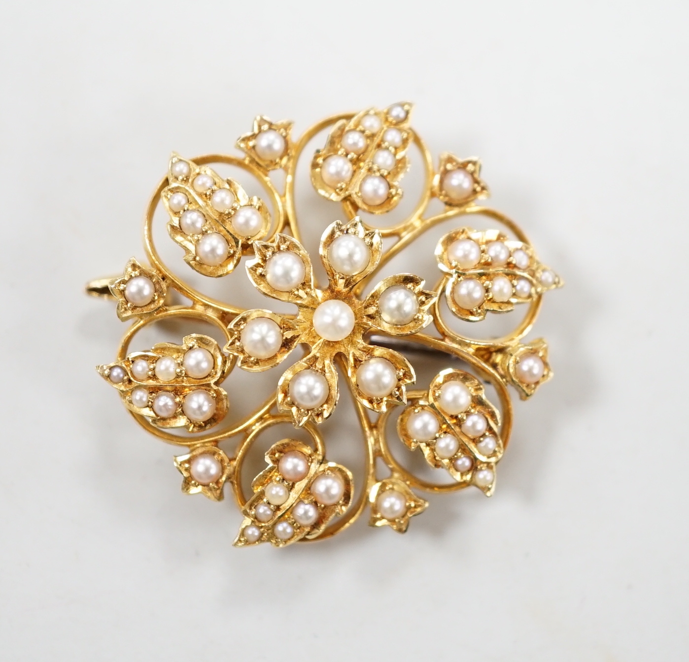 An Edwardian 15ct and seed pearl cluster set flower head brooch, 28mm, gross weight 6.3 grams.
